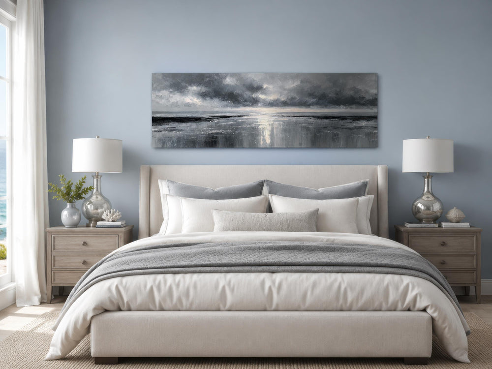Stormy Ocean long horizontal grey and silver canvas wall art hanging above a bed in a bedroom.