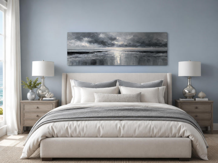 Stormy Ocean long horizontal grey and silver canvas wall art hanging above a bed in a bedroom.