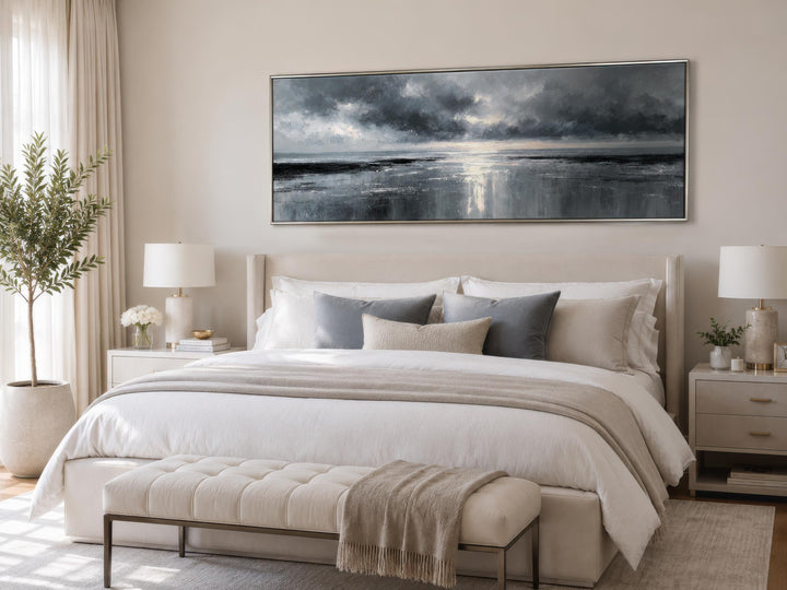 Stormy Ocean horizontal grey and silver canvas wall art hanging above a bed in a neutral bedroom.