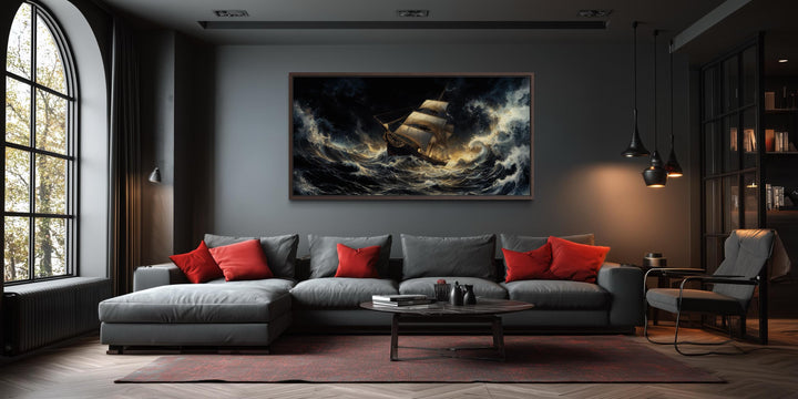 A dramatic canvas print of a sailing ship in a stormy ocean hangs above a modern gray sofa.