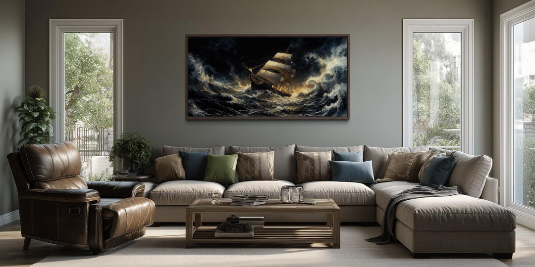 A dramatic canvas print of a sailing ship in a stormy ocean hangs above a modern sectional sofa.