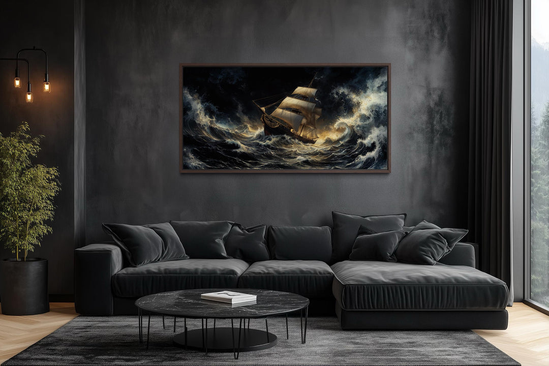 A dramatic canvas print of a sailing ship in a stormy ocean hangs above a modern black sofa.