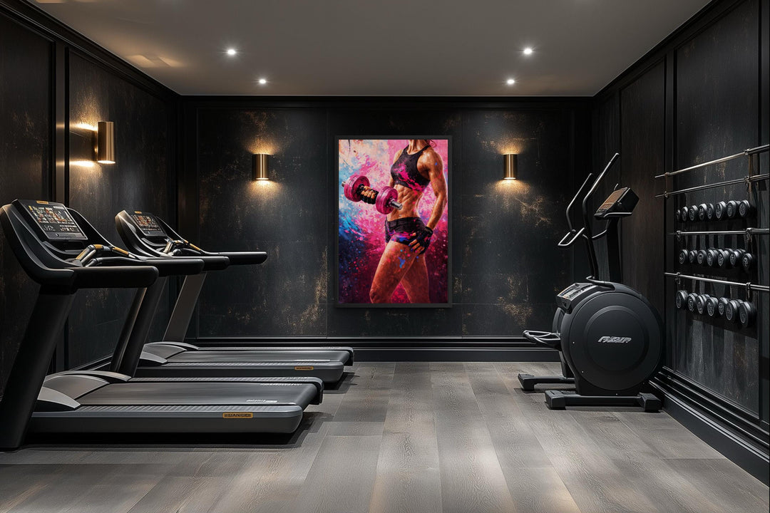 A motivational canvas print of a strong woman lifting a dumbbell in a modern, dark home gym.