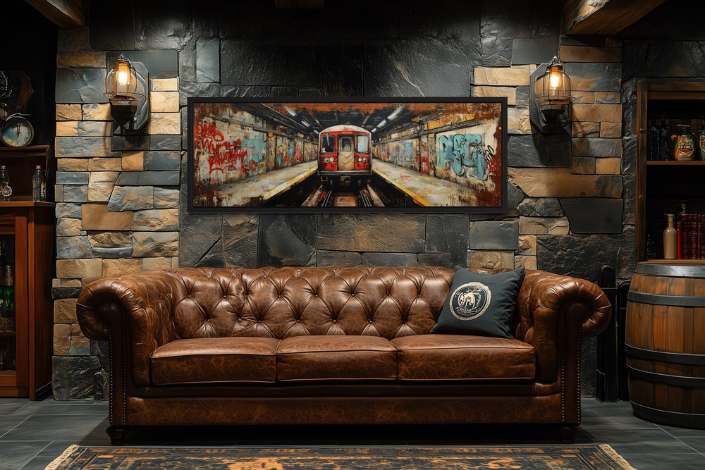 Panoramic subway train graffiti wall art above a brown leather sofa in an industrial man cave.