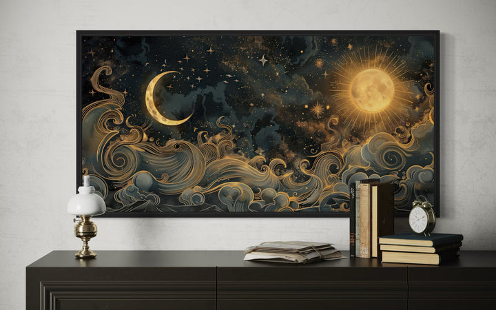 Framed black and gold celestial canvas art featuring a sun, crescent moon, and swirling clouds.