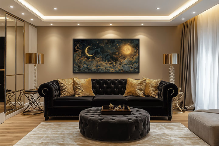 Framed black and gold sun and moon celestial canvas wall art hanging above a black velvet sofa.