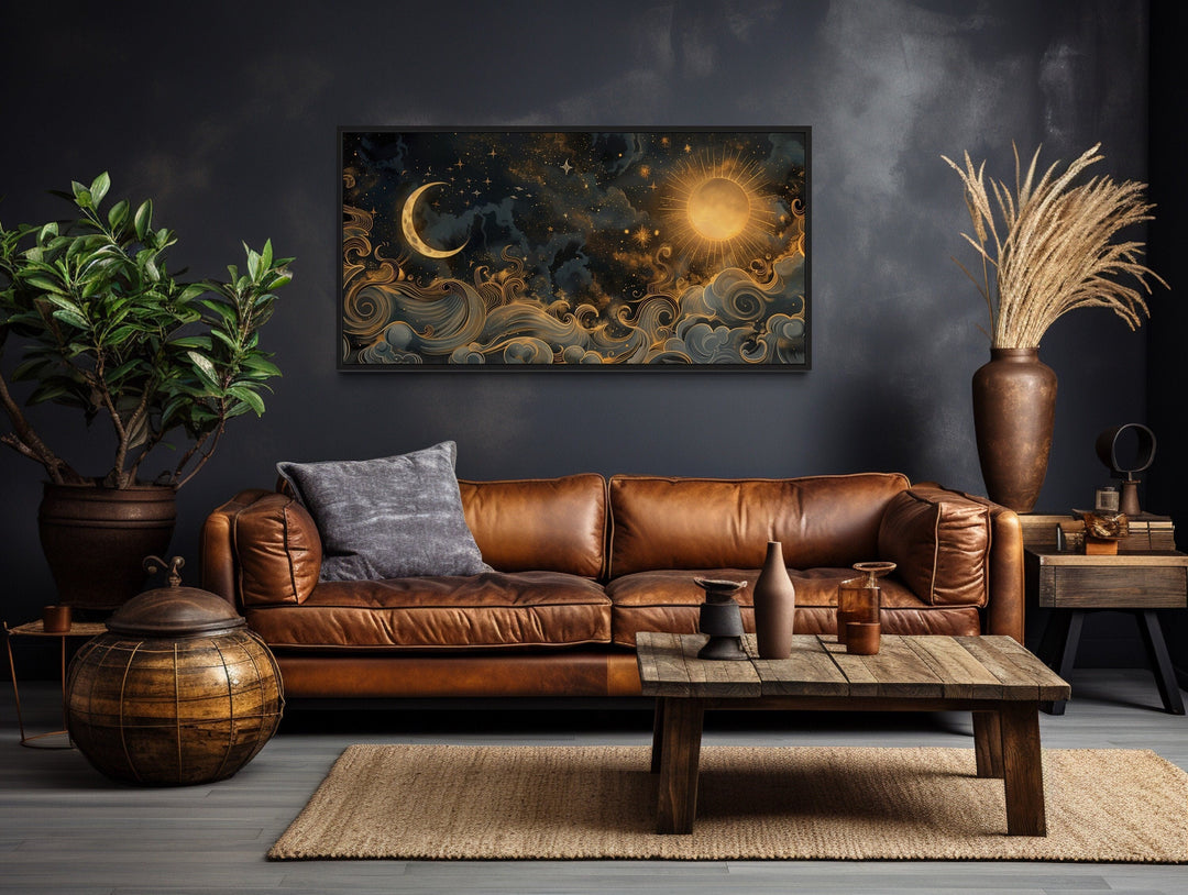 Framed black and gold celestial canvas art featuring a sun and moon above a brown leather sofa.