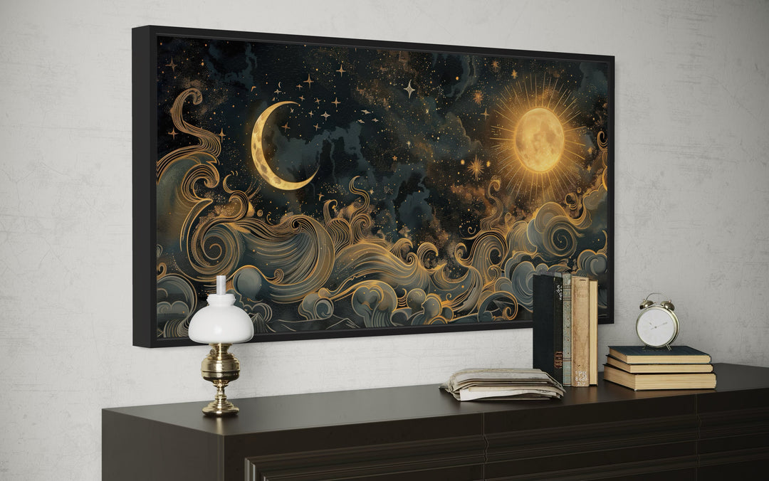 Framed black and gold celestial canvas art featuring a sun, crescent moon, and swirling clouds.