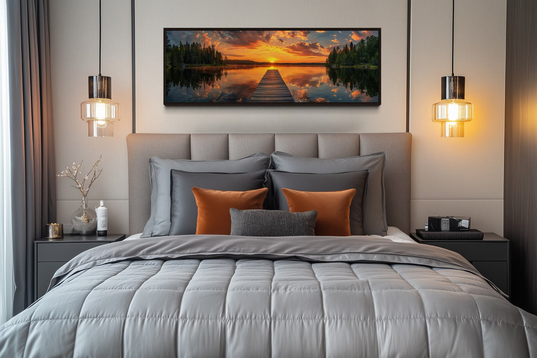Sunrise over lake and fishing pier long horizontal canvas wall art hanging above a bed.