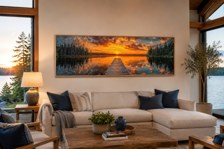 Sunrise over lake and fishing pier long horizontal canvas wall art hanging above a living room sofa.