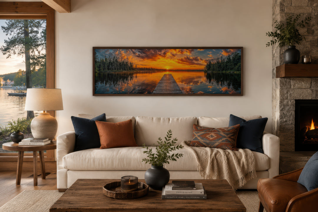 Sunrise over lake and fishing pier long horizontal canvas wall art hanging above a cream sofa.