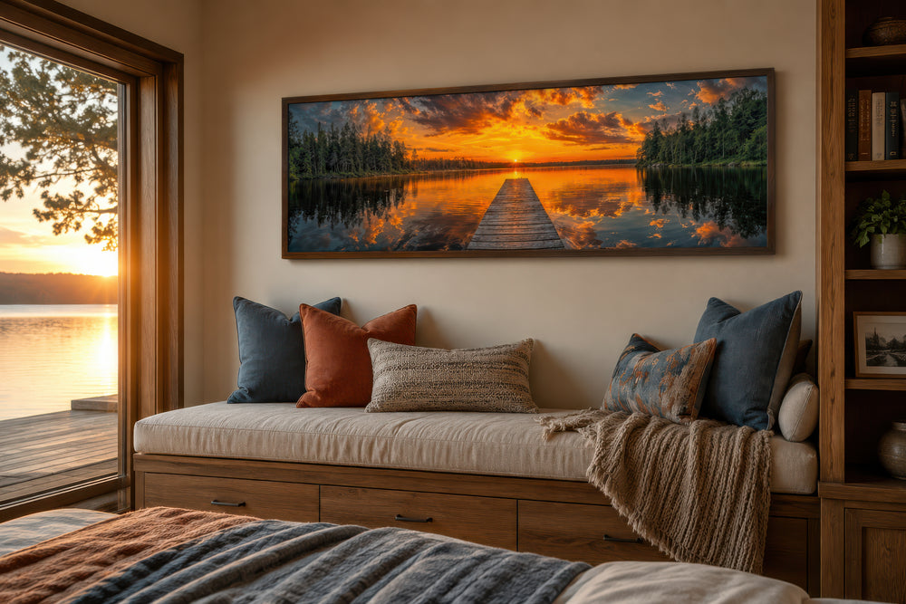 Sunrise over lake and fishing pier long horizontal canvas wall art above a wooden window bench.