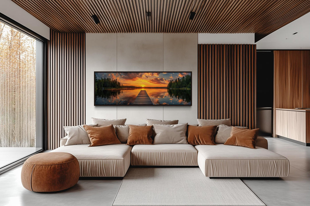 Sunrise over lake and fishing pier long horizontal canvas wall art hanging above a modern sofa.