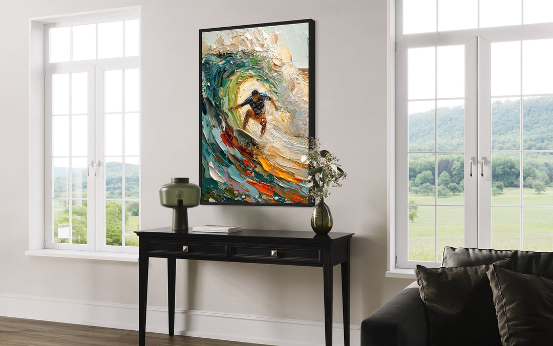 Surfer riding a wave framed canvas wall art displayed above a black console table in a modern room.