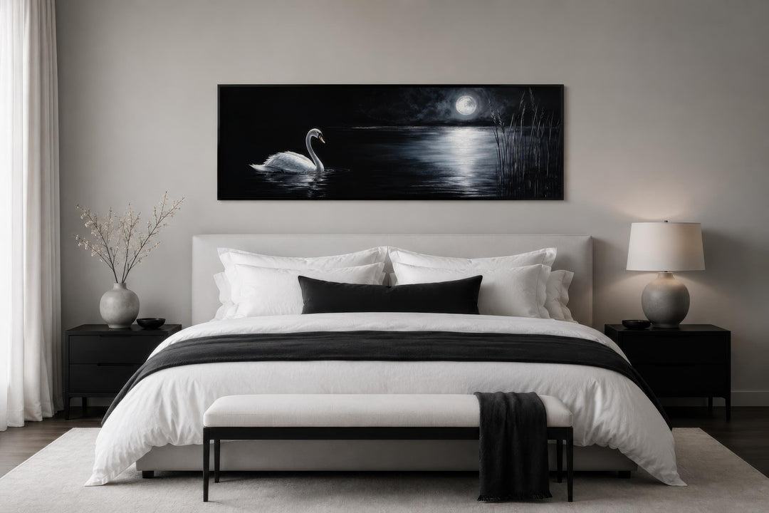 Long narrow canvas print of a white swan on a dark lake under a full moon above a modern bed.