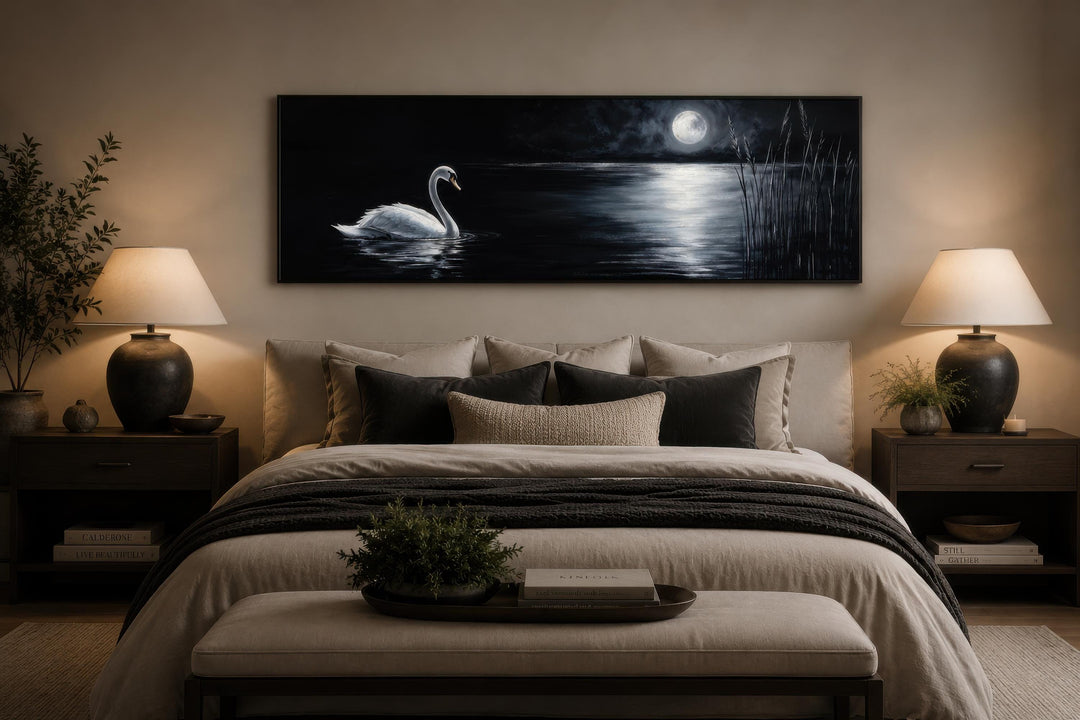 Long narrow canvas print of a white swan on a dark lake under a full moon above a bed.