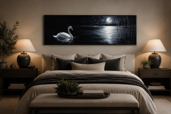 Long narrow canvas print of a white swan on a dark lake under a full moon above a bed.