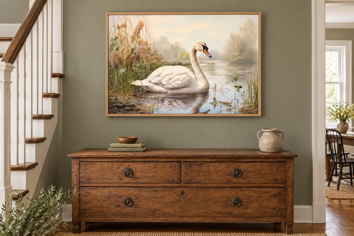 White swan in a lake vintage style framed canvas wall art hanging above a rustic wooden dresser.