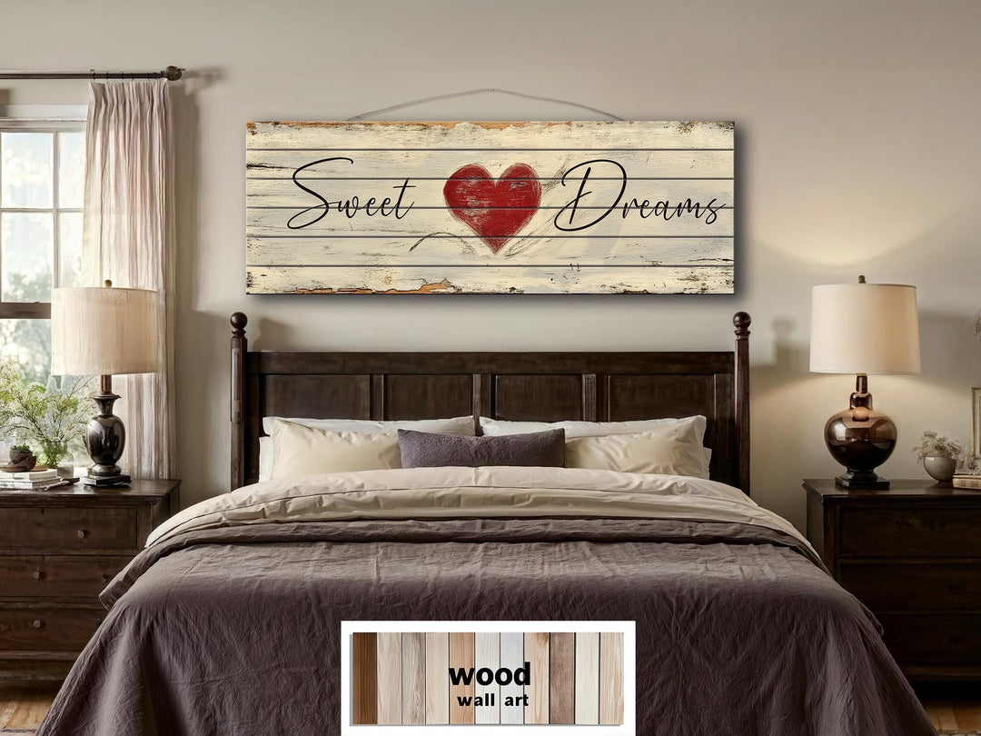 Rustic wood wall art with Sweet Dreams script and a red heart hanging above a bed.