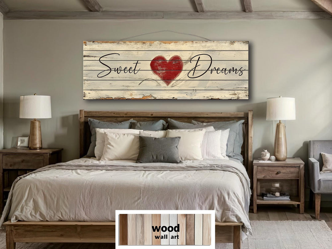 Rustic wood wall art with Sweet Dreams and a red heart hangs above a bed in a farmhouse bedroom.