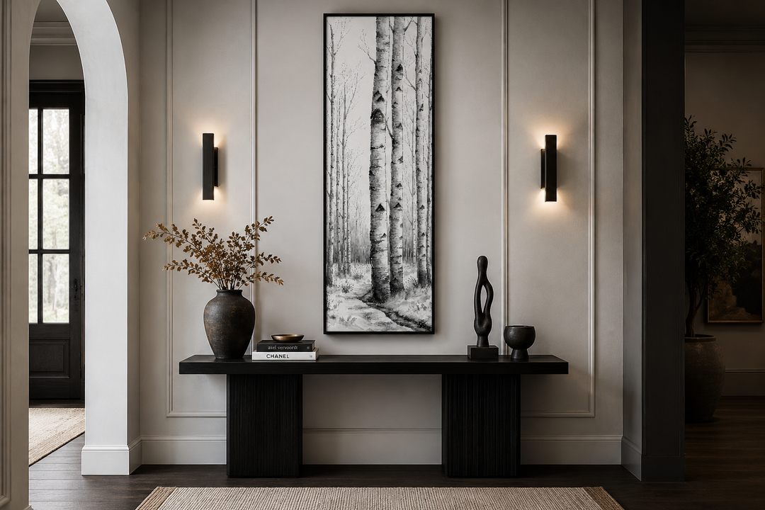 Tall narrow vertical framed canvas wall art featuring black and white birch trees in a winter scene.