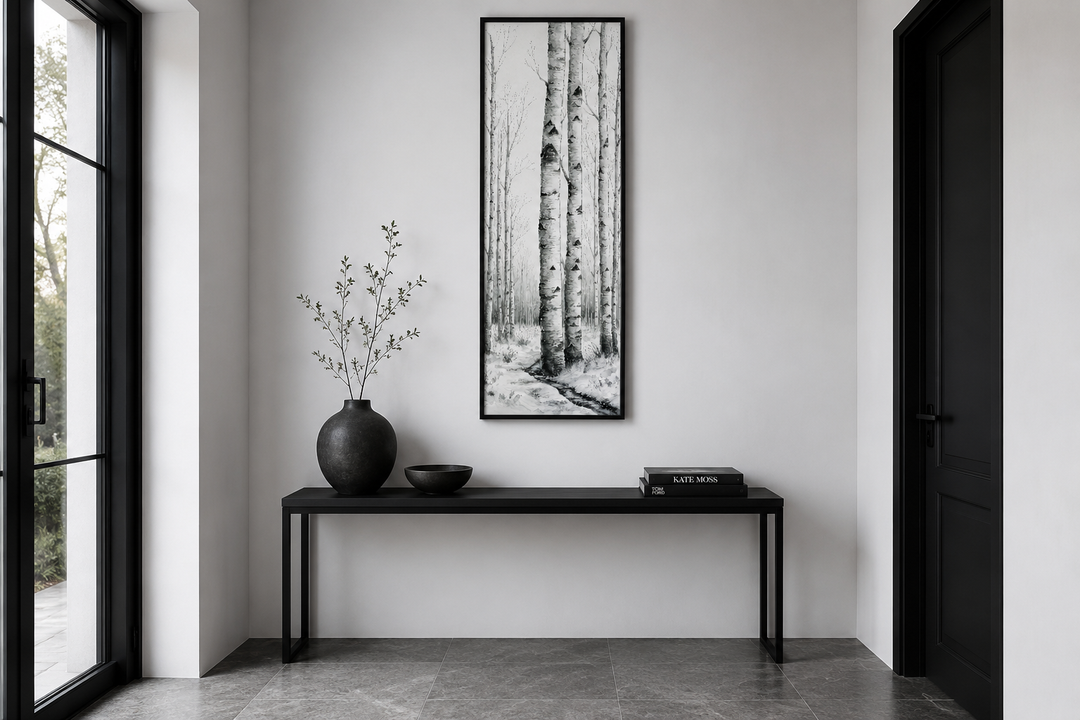 Tall narrow black and white vertical framed canvas wall art featuring birch trees in a winter scene.