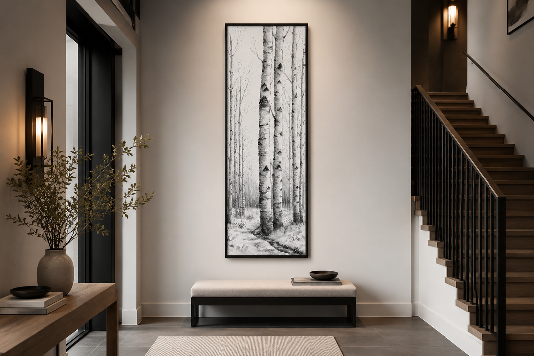 Tall narrow vertical framed canvas wall art featuring black and white birch trees in a winter scene.