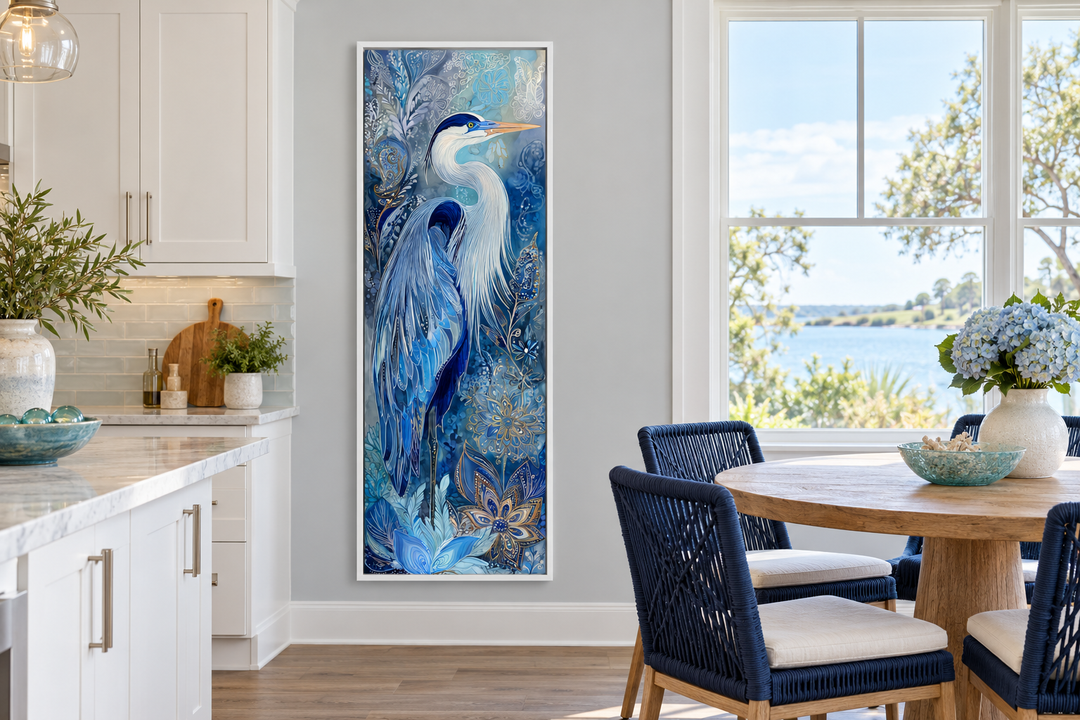 Tall narrow blue heron canvas print in a white frame on a grey wall in a coastal dining area.