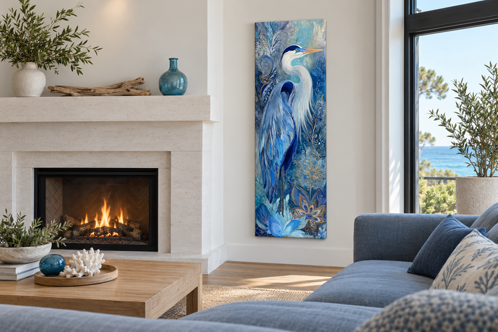 Tall narrow canvas print of a blue heron in a modern living room with a fireplace and blue sofa.