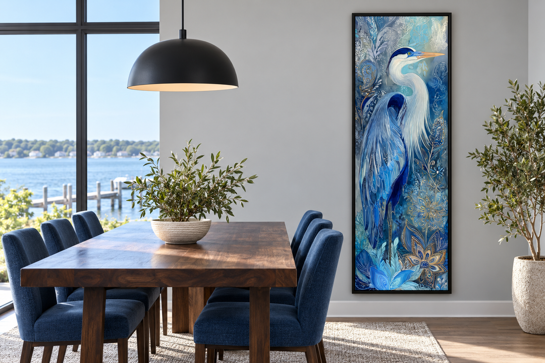 Tall narrow canvas print of a blue heron in a black frame on a dining room wall.