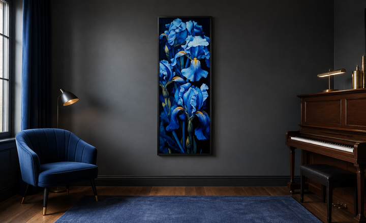 Tall narrow framed canvas wall art featuring blue irises on a black background in a dark room.