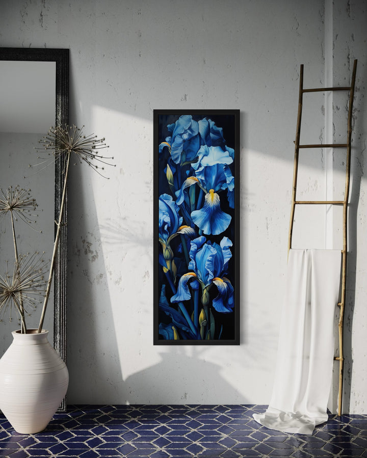 Vertical framed canvas wall art featuring tall blue irises on a black background in a modern room.