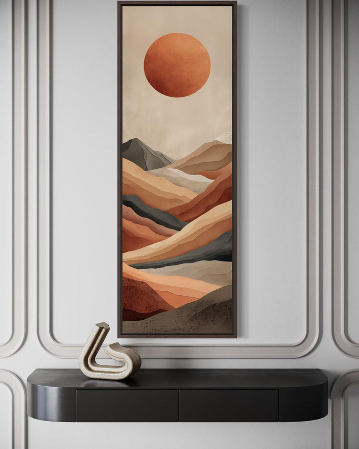 Vertical canvas print of a terracotta desert landscape with a large sun in a narrow dark frame.