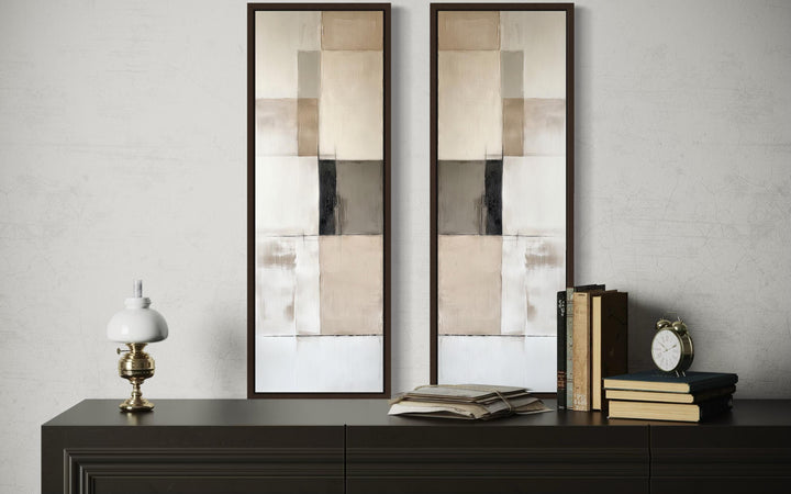 Narrow geometric neutral abstract set of 2 canvas wall art in tall frames on a dark console table.