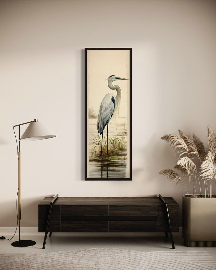 Tall narrow framed canvas wall art featuring a great egret standing in a marshy coastal landscape.