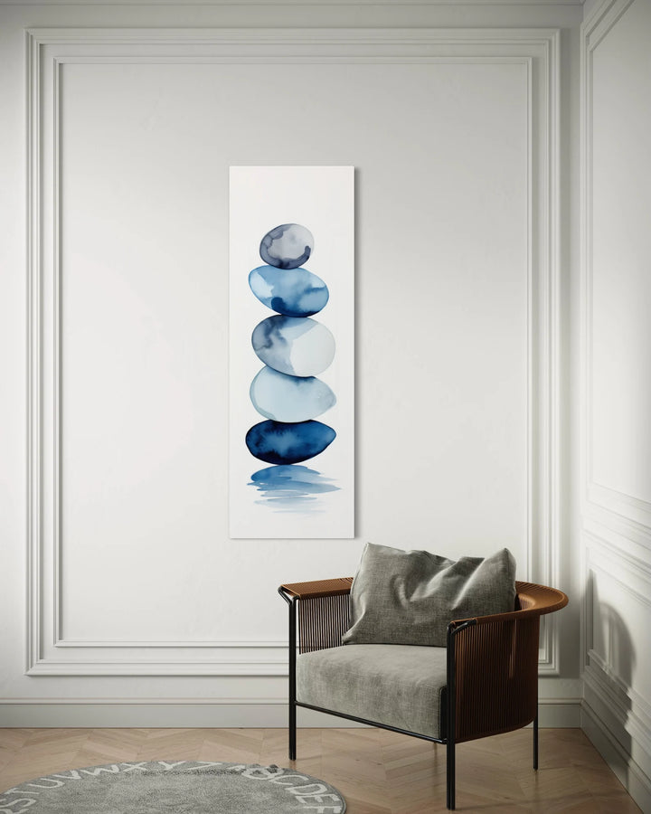 Tall Narrow Navy Blue White Stacked Rocks Vertical Framed Canvas Wall Art behind a chair