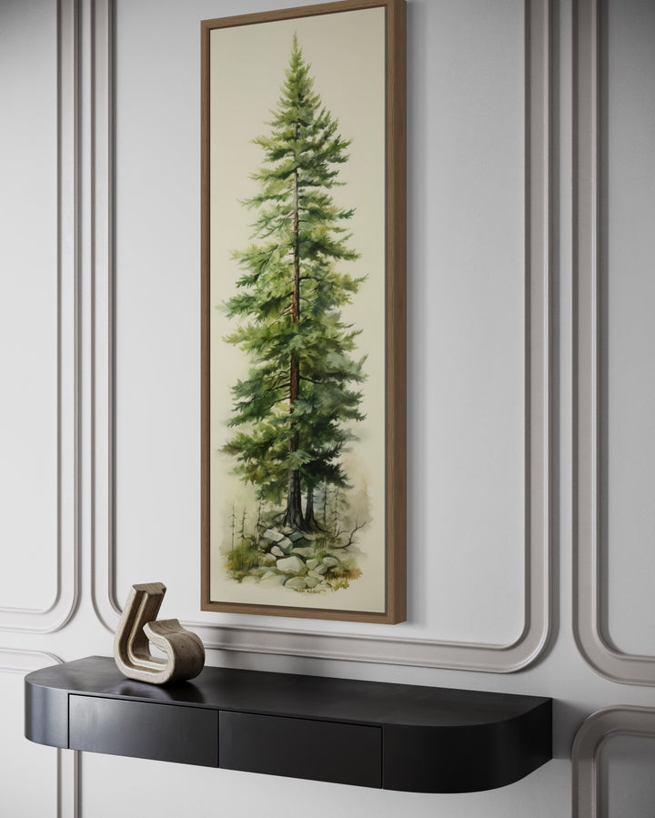 Tall narrow pine tree vertical framed canvas wall art hanging above a black console table.