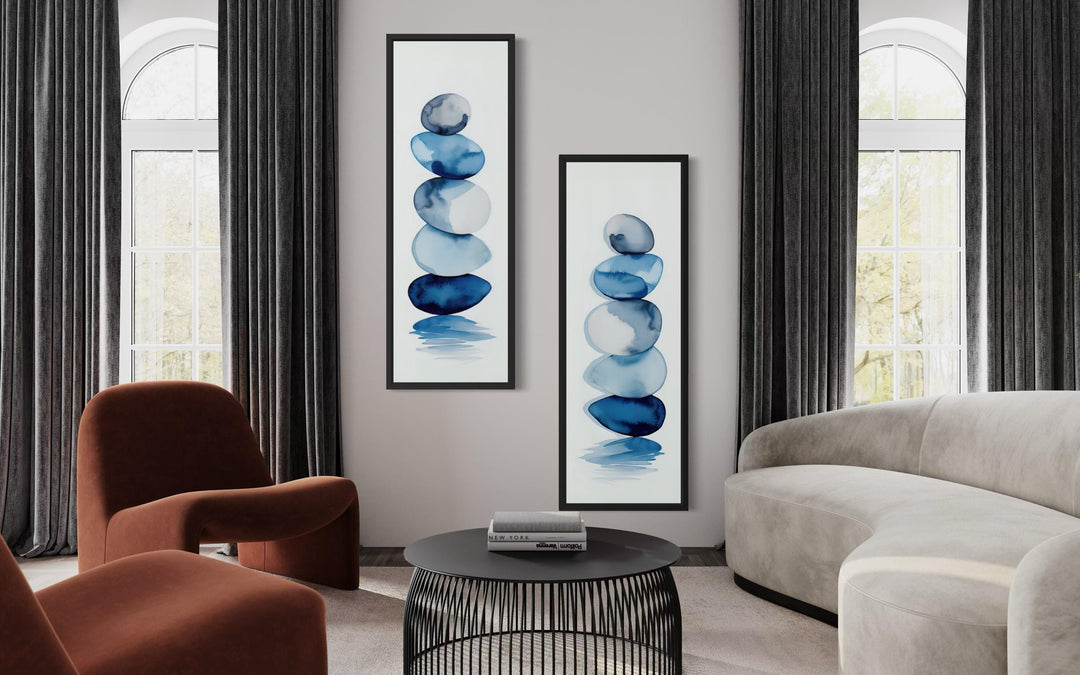 Set of 2 tall narrow canvas prints featuring stacked blue watercolor zen stones in a modern room.