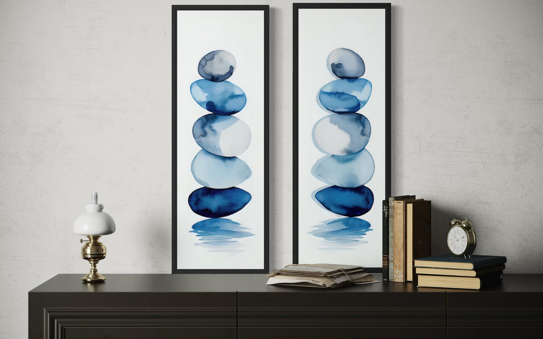 Set of two tall narrow canvas prints featuring stacked blue watercolor zen stones on white.