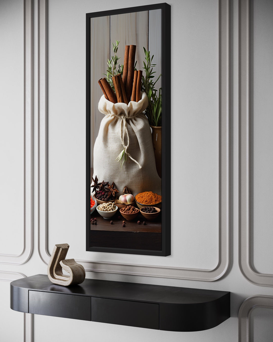 Tall narrow framed canvas wall art of herbs and spices in a kitchen setting above a black console.