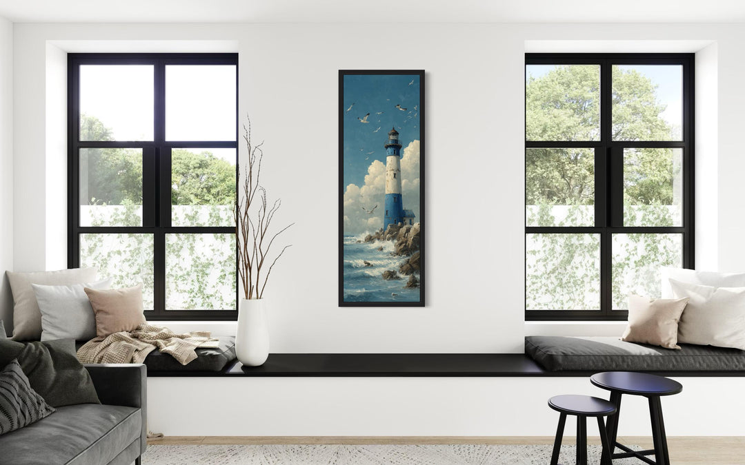 Tall slim lighthouse canvas wall art in a vertical narrow frame between two windows.