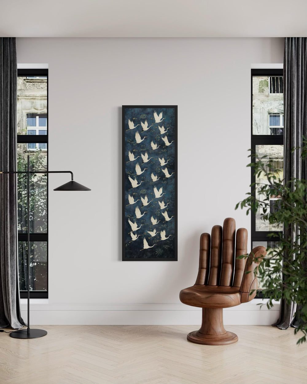 Tall vertical navy canvas wall art featuring white flying cranes in a black frame on a white wall.