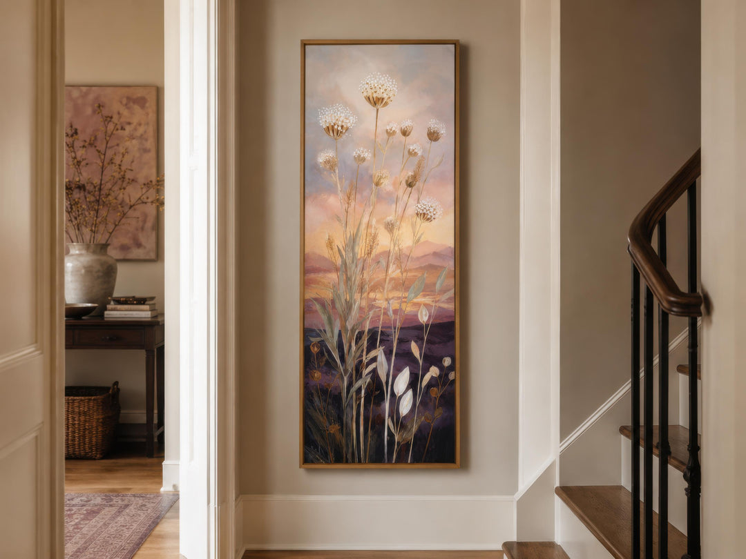 Tall vertical canvas art of wildflowers against a gold and purple sunset in a hallway.