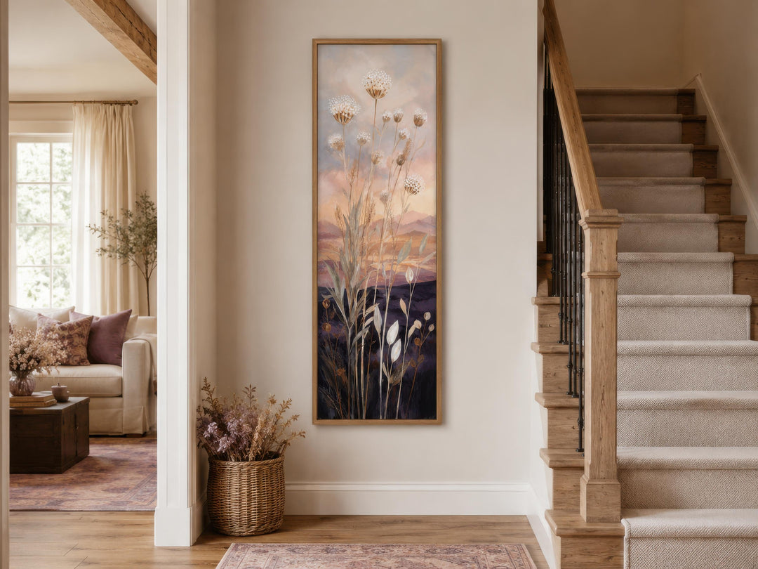 Tall vertical canvas art of wildflowers against a gold and purple sunset in a narrow hallway.