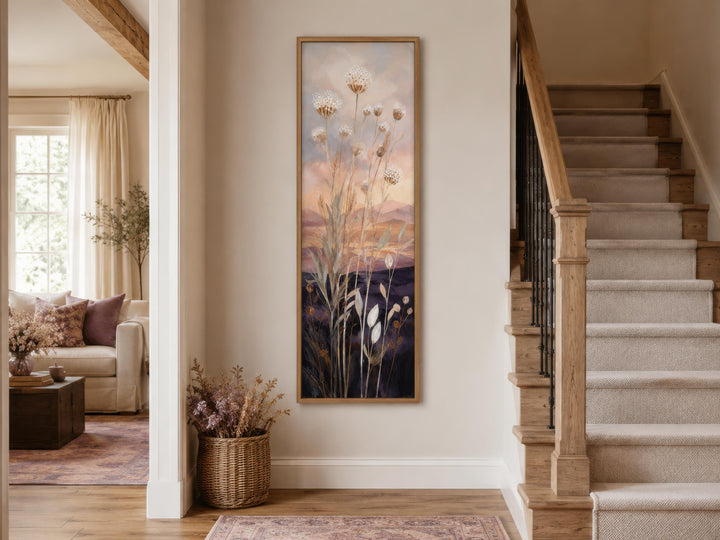 Tall vertical canvas art of wildflowers against a gold and purple sunset in a narrow hallway.