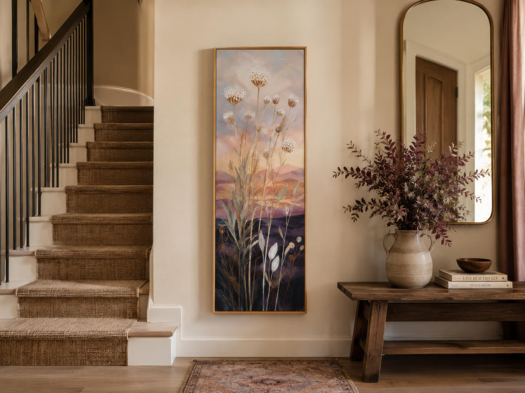 Tall vertical canvas art of wildflowers against a gold and purple sunset in a home entryway.