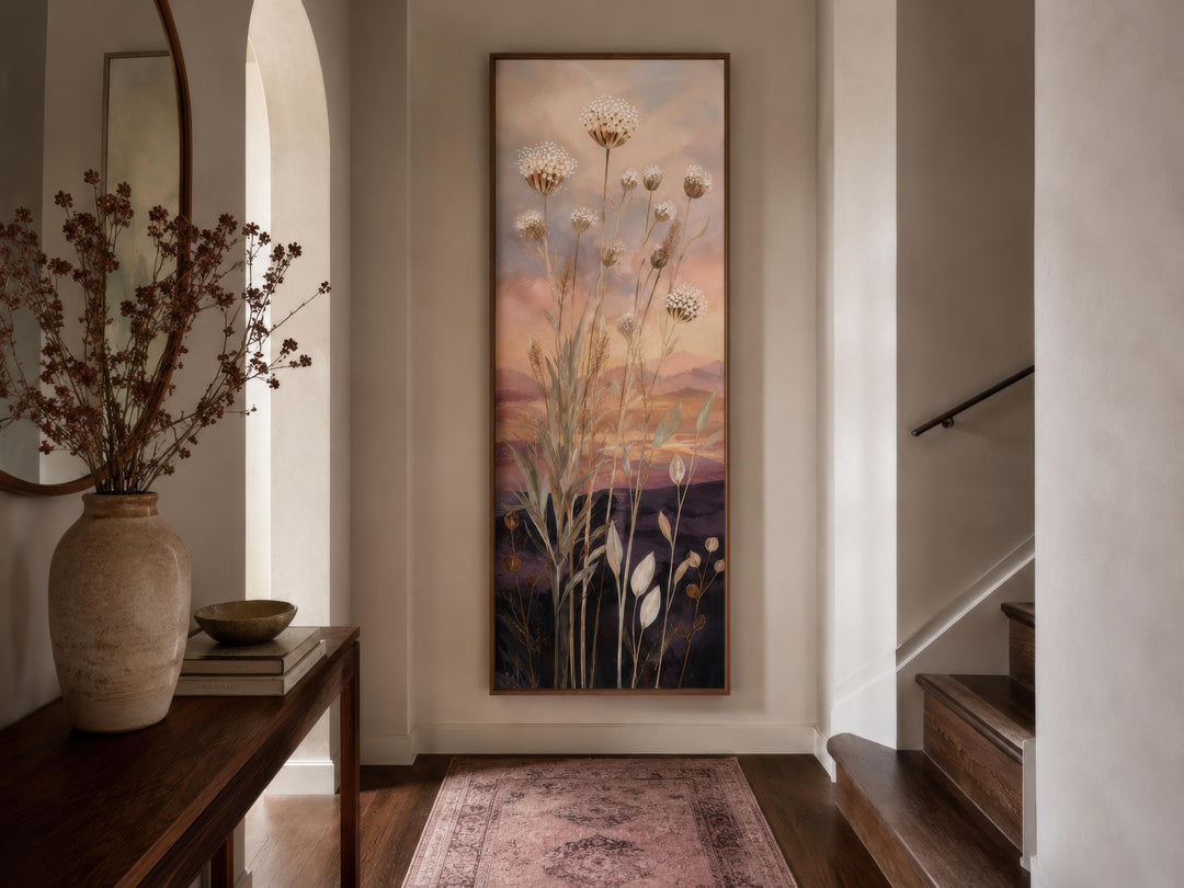 Tall vertical canvas art of wildflowers against a gold and purple sunset in a hallway.