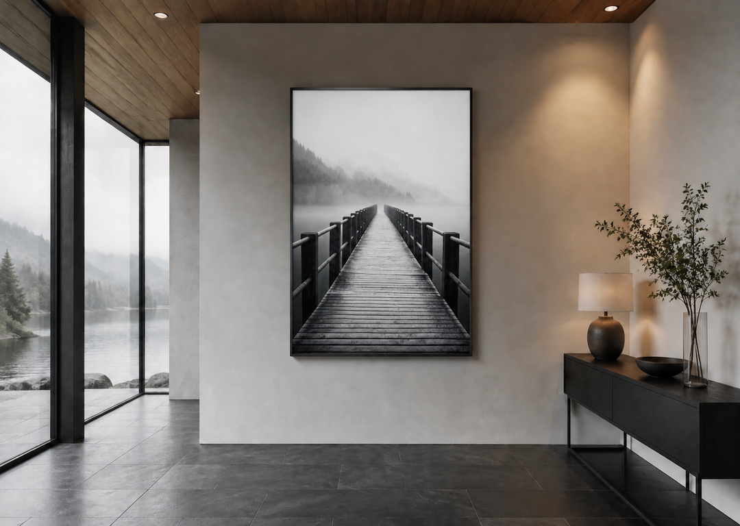 Foggy black and white landscape of a wooden pier stretching into a misty lake, framed on a wall.
