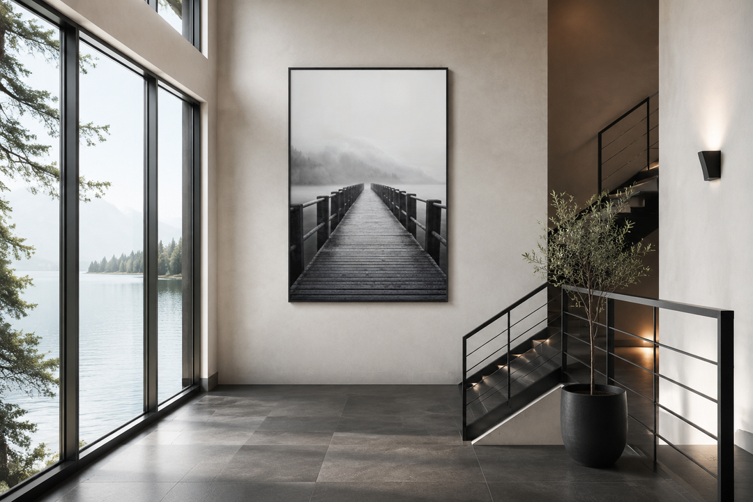 Foggy black and white lake landscape with a dock framed canvas wall art in a modern hallway.