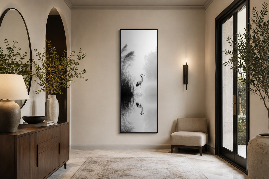 Tall narrow black and white canvas print of a Japanese crane in a foggy lake on a neutral wall.